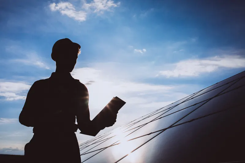 Instalador colocando placas solares al atardecer en Avilés